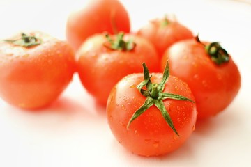 Ripe red tomatoes on a white isolated background.