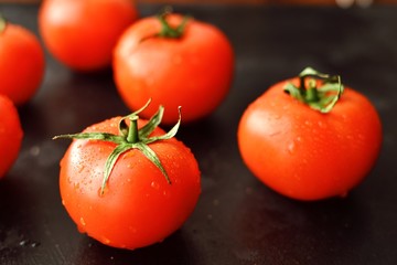 Ripe red tomatoes on a dark background, table, isolated.