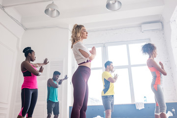 Low angle view of multicultural dancers performing zumba movements in dance studio
