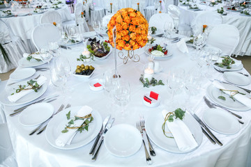 Holiday table setting decorated with flowers and candles.