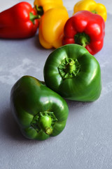 Two green fresh bell pepper with multi-colored sweet peppers. Green, red and yellow vegetables. Healthy food concept