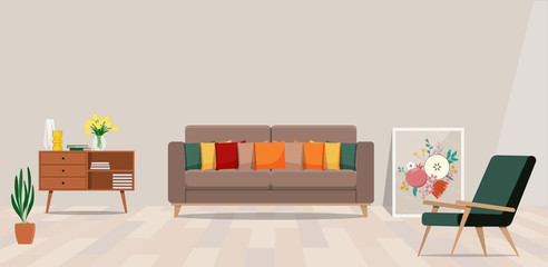 Cozy living room with beige sofa and cushions, green chair and a painting on the floor.