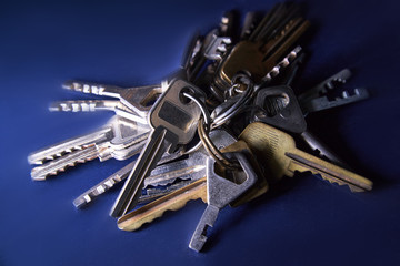 Pile of many different yellow and white old metal keys choice to open a door. Vintage close-up background