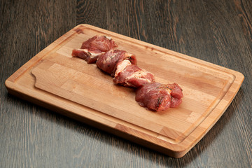 raw meat skewers on a wooden cutting Board