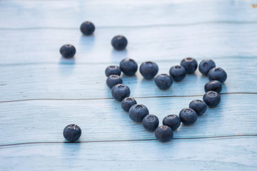 Valentines day concept: blueberry heart on a wooden background.