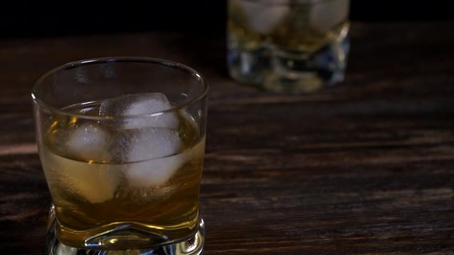 Ice cubes melts in a glass of  malt whiskey 