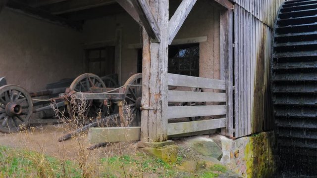 Cobertizo de viejo molino para serrería de madera y rueda girando con cascada de agua