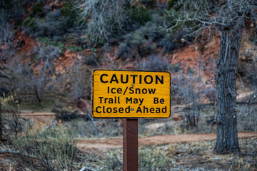 Caution "ice & snow" sign in Zion National Park during winter