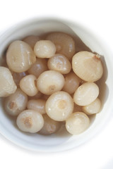 Pickled little pearl onions in a bowl isolated on white background