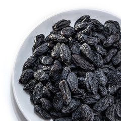 Dark raisins on a white isolated background. Food brown-blue grapes delicious for your design for the site. kitchen theme