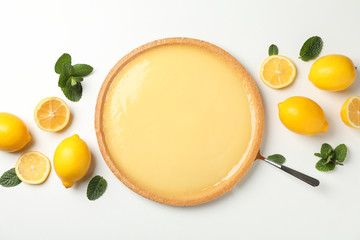 Lemon tart, mint and lemons on white background, top view
