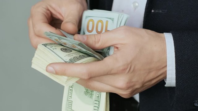 Men's hands quickly count banknotes. Businessman counts dollars in hands. USD