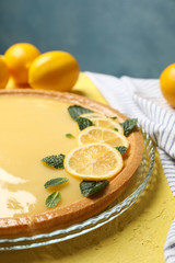 Composition with lemon tart on yellow background, close up
