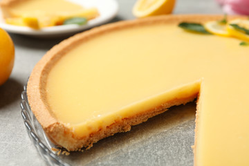 Composition with lemon tart on grey background, close up