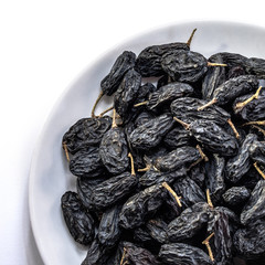 Dark raisins on a white isolated background. Food brown-blue grapes delicious for your design for the site. kitchen theme