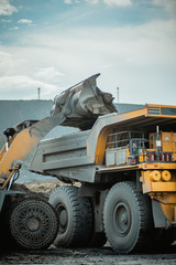Wheel loader loads a mining dump truck with ore.  © CjVitoS