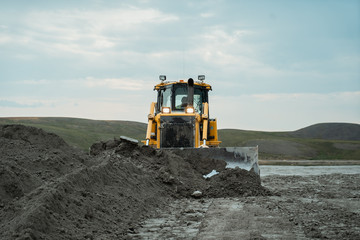 The bulldozer works in the quarry.  - obrazy, fototapety, plakaty