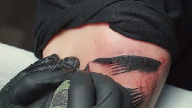 Video of man tattooist getting tattoo of snake