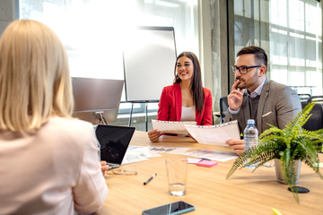 Group of young modern people in smart casual wear discussing business while working in the creative office. Passionate about their project. Group of business persons in discussion