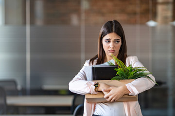 Close up view of new female employee intern holding cardboard box with belongings start finish job in company office, busnesswoman newcomer worker get hired fired on first last day at work concept