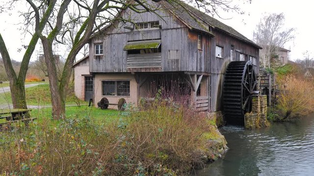 Frontal de viejo molino de madera con rueda de aspas en campi&ntilde;a de oto&ntilde;o