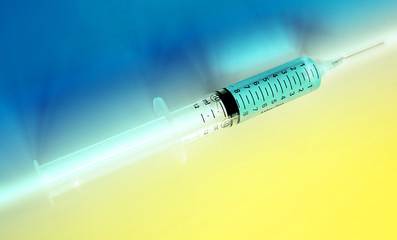 Syringe on blue and yellow background