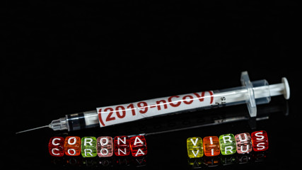 Colorful text "Corona virus" and   syringe have red text "(2019-nCoV)  put on  Black background. corona virus Concept.
