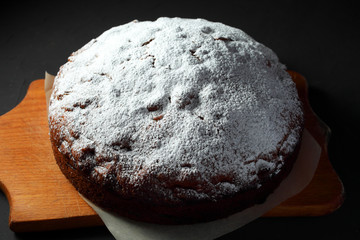 homemade powdered sugar cake on a dark background