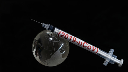 Syringe have text "(2019-nCoV)" and globe model  put on  Black background. corona virus Concept.