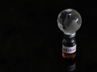 Vaccine bottle have  text "Corona virus" and  Globe model put on  Black background. corona virus Concept.