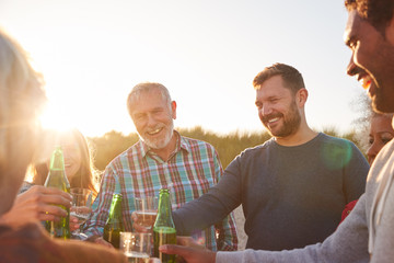 Multi-Generation Adult Family Celebrating With Wine On Winter Beach Vacation