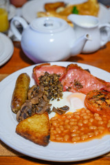 Full Scottish breakfast with bacon, fried egg, beans, tomato, roasted sausage, pudding, hash browns and haggis