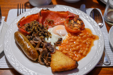 Full Scottish breakfast with bacon, fried egg, beans, tomato, roasted sausage, pudding, hash browns and haggis