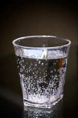 Plastic transparent glass with sparkling water with bubbles