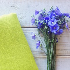 Linen flowers bouquet and lime color linen fabric on the wooden white table