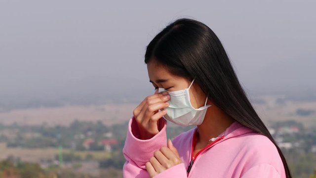 Asian women wearing dust mask and headache protect from wuhan coronavirus china health emergency.