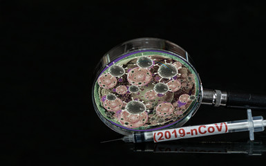 syringe have red text "(2019-nCoV) and Magnifying glass have The virus-like spot is there.  Placed on a black background.  The outbreak of corona virus Concept.