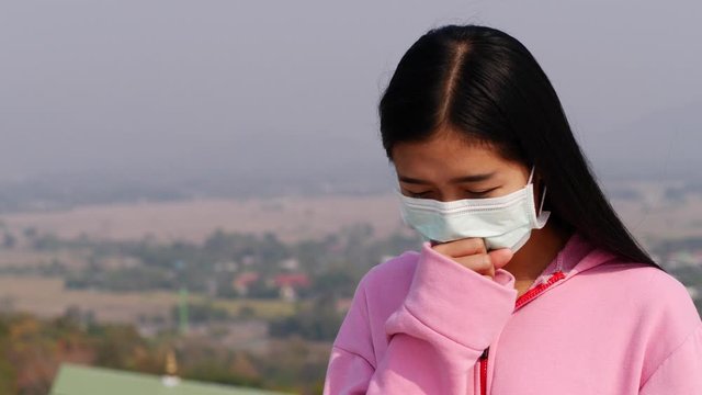 Asian women wearing dust mask and headache protect from wuhan coronavirus china health emergency.