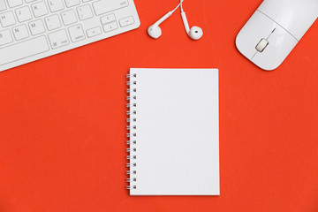 Minimal workplace with blank notepad, keyboard and supplies on colored background. Top view. Flat lay