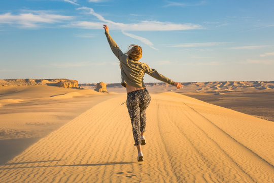 Happy girl jumping in the desert celebrating her freedome - Powered by Adobe