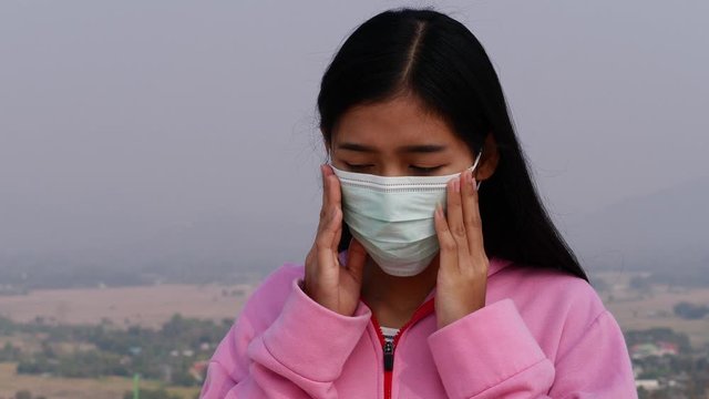 Asian women wearing dust mask and headache protect from wuhan coronavirus china health emergency.