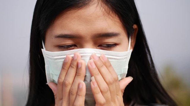 Asian women wearing dust mask and headache protect from wuhan coronavirus china health emergency.
