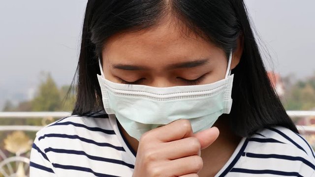 Asian women wearing dust mask and headache protect from wuhan coronavirus china health emergency.