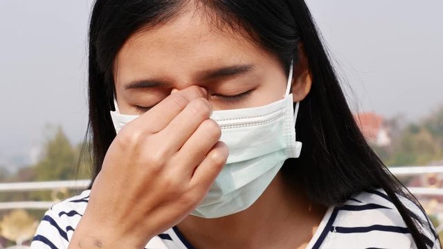 Asian women wearing dust mask and headache protect from wuhan coronavirus china health emergency.