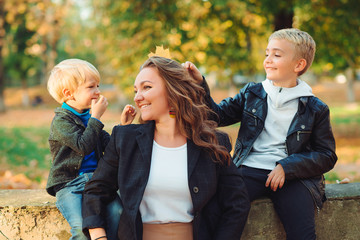 Happy family together. Mother and two son playing and laughing on autumn walk. Family, fashion and...