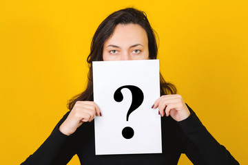 Thoughtful woman holding guestion mark. Problems and solutions concept. Girl hiding face behind question mark symbol