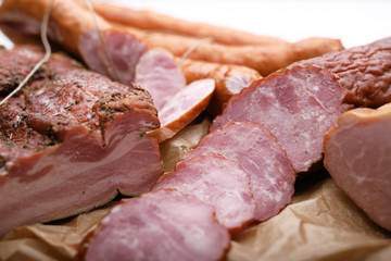 Composition of smoked cold cuts on a paper. Traditional meat products.