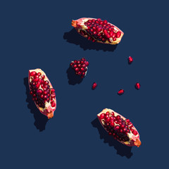 Flat lay layout with summer pomegranate fruit on blue background. Minimal concept with sharp...
