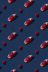 Flat lay pattern with summer pomegranate fruit on blue background. Minimal concept with sharp...