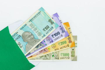 The brand new Indian currency bank notes of 50, 100, 200 and 500 rupees, New Indian Currency  in green envelope on white background, Success and got profit from business